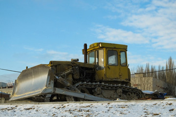 Dirty yellow bulldozer. on the winter road because construction stopped
