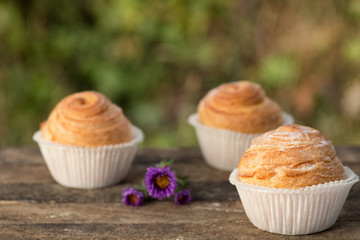 Close up fresh baked golden muffins and biscuit on rustic wooden background shot in natural light