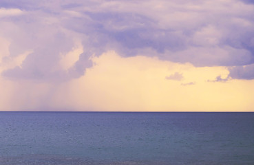 Obraz premium Beautiful sunset over the sea. Rain clouds on the horizon.