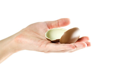 Hand holding a chocolate egg. Close up. Isolated on white background