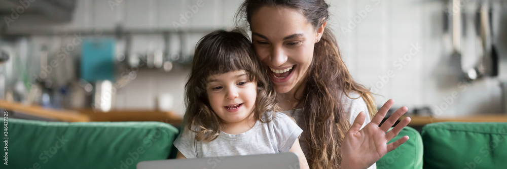 Wall mural mixed race mother and daughter using computer make video call waving hands greeting friend, having f