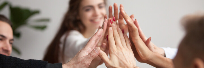 Horizontal close up photo young business team giving high five celebrate success join hands together feels happy, symbol of team spirit support teamwork unity concept, banner for website header design