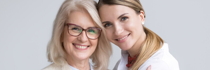 Close up attractive women faces smile look at camera, aged mother young daughter, different...