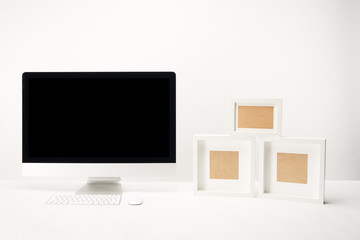 workplace with photo frames and desktop computer with copy space isolated on white