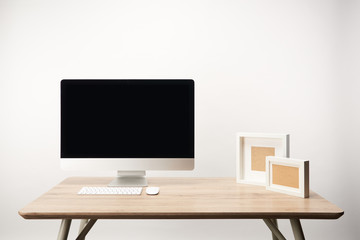 workplace with photo frames and desktop computer with copy space isolated on white