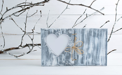 Home interior decor in honor of Valentines Day with photo frame in shabby chic style with heart mockup on background of branches covered with hoarfrost