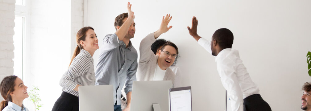 Happy diverse workmates giving high five celebrating corporate success feels excited in workplace, succeed common goal career growth concept, banner for website header design with copy space for text