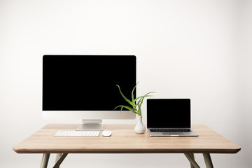 workplace with desktop computer and laptop with copy space on wooden table isolated on white