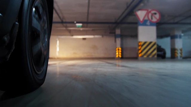 Underground parking. Wheel of car moving foward