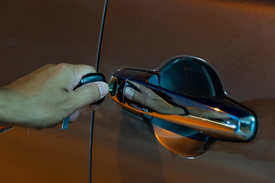 Hand Of Men Use Key On Open Door Of Car At Night.