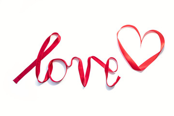 Word "love" written with red silk ribbon