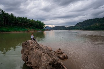 Sunset at mekong river. Some boats in the river. Cloudy scene in luang prabang, laos.