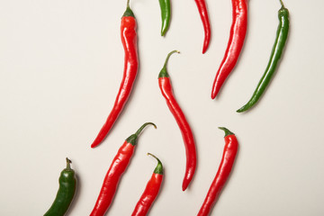 Flat lay with red and green chili peppers on grey background