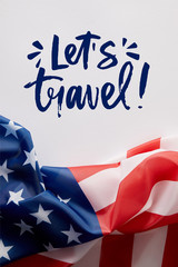 Fototapeta na wymiar top view of united states of america flag and lets travel lettering on white surface