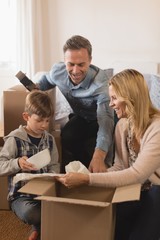 Family unpacking cardboard boxes in their new home