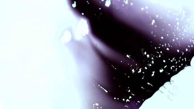 Ink is squashed in between 2 sheets of glass and spreads out creating colourful effects