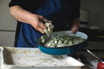 Foto op Canvas Old woman making a pie by her recipe © rastkobelic
