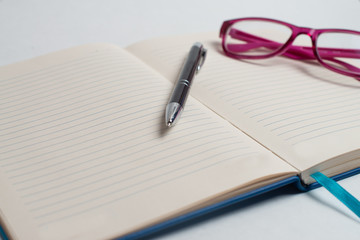 Fototapeta premium Notebook with black pen, Colorful notepads on the desk, Glasses on the desk with pen and cup of coffee, Computer keyboard with colorful note stick