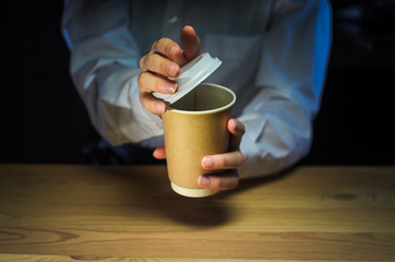 Barista serves coffee to the client. Hands Paper cup Bar counter Cappuccino Plastic cap. Coffee Business Concept