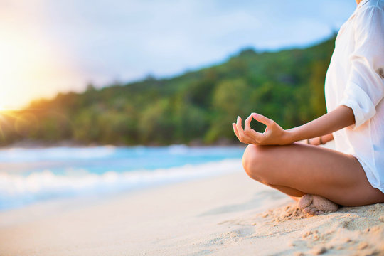 Closeup of Woman's Practicing Lotus Pose on the Beach at Sunset