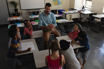 Male teacher teaching in classroom of elementary school
