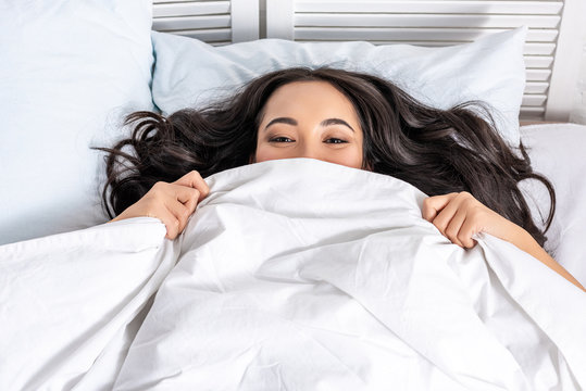 Young Asian Beautiful Woman Hiding Under Blanket