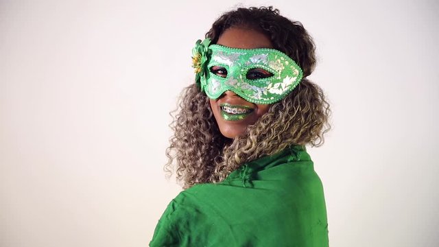 Beautiful Brazilian black female model posing in carnival mask with bright makeup and gren lipstick. Covering with Brazilian flag.