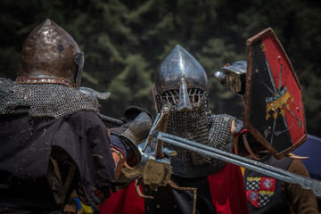 Medieval knights fighting with armor, swords and shields in festival