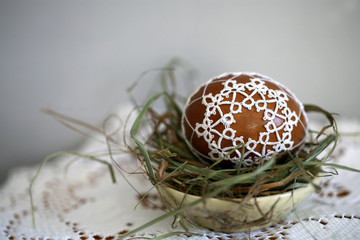 Polish Easter eggs decorated with lace tatting in a straw nest. Easter decoration 