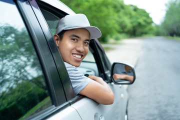 asian young man driver look back from the open windows look at the camera