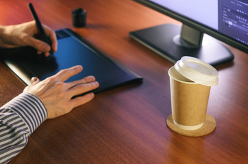 Desktop side view. Computer Graphics Tablet Cup of coffee Hand. Concept for website banner, mockup,...