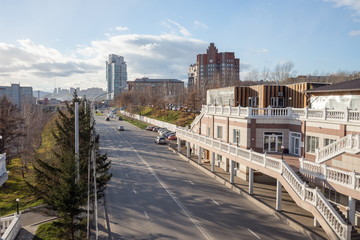 Fototapeta premium View of the roadway on Dubrovinsky Street with residential buildings in the distance in the city of Krasnoyarsk. Russia.