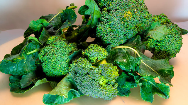 Fresh broccoli on dark wooden table background. Close up front view