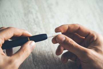 man hand holding electric cigarette on table