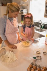 Obraz na płótnie Canvas Mother with her daughter preparing food in kitchen