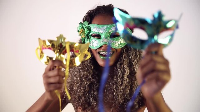 Beautiful Brazilian black female model posing in carnival mask with bright makeup and gren lipstick.