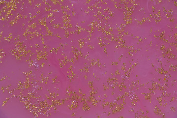 white ink in pink water with gold glitter/ abstract glitter background 