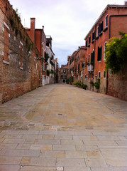 One of the few venetian traditional street without water, with medieval houses, Venice, Italy