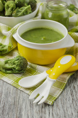 Fresh broccoli in the bowl, and portion of puree made from crushed broccoli, blurred background