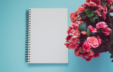 notepad on a blue background. with pink flowers