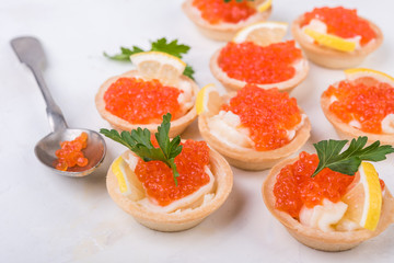 Tartlets with red caviar on white background. Selective focus.