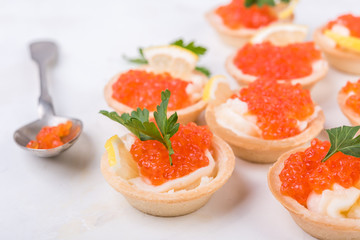Tartlets with red caviar on white background. Selective focus.