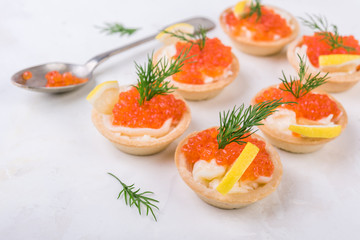 Tartlets with red caviar on white background. Selective focus.