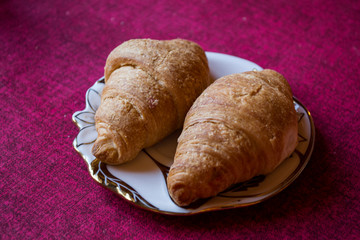 The croissants in a plate on a table, close up.