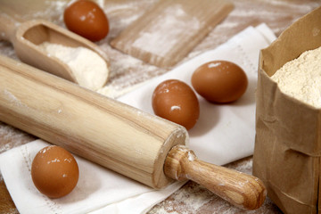 Fresh egg pasta homemade preparation. Eggs, flour and rolling pin on a wooden table