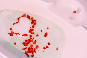 Romantic bath with rose. St. Valentine's Day bath. Aromatherapy with flower petals.