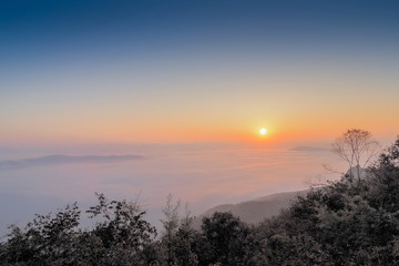 sunrise at Doi Samur Dao, mountain view misty morning of the hill around with sea of mist with colorful of yellow sun light in the sky background, Sri Nan National Park, Nan Province, Thailand.