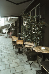 Street photography in Tirana. Coffee bar on the side road. Small rounded coffee tables.