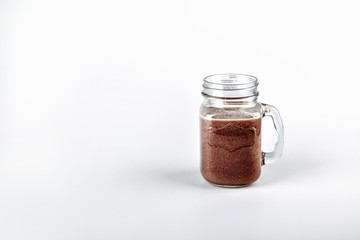 Fresh protein shake, milk with cocoa in a glass jar on a white background