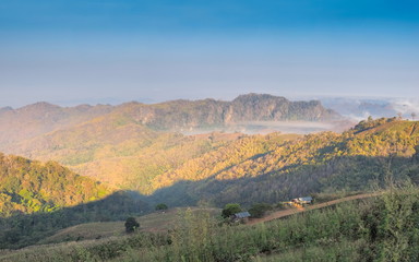 sunrise at Doi Samur Dao, mountain view misty morning of the hill around with sea of mist with blue sky background, Sri Nan National Park, Nan Province, Thailand.